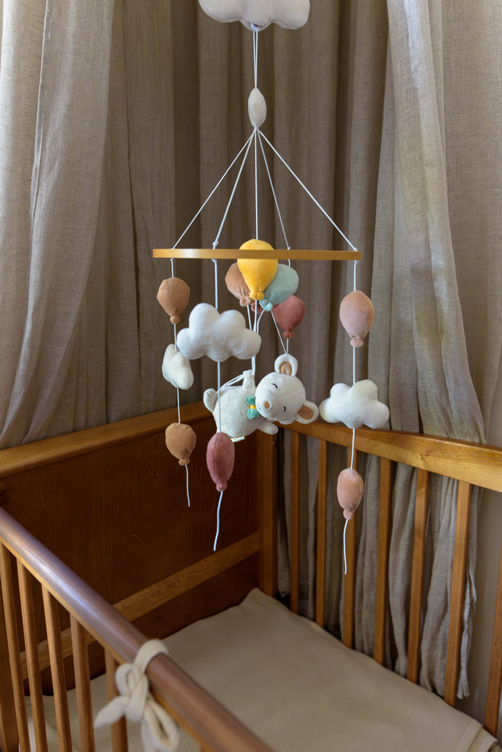 Babiem Musical Mobile Sam with plush balloons, clouds, and a bear above a crib.