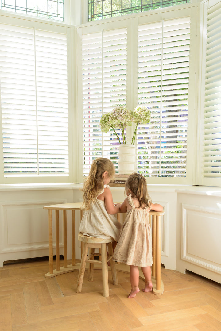 Two young kids drawing while using Babiem Climbing Arch Ben, a natural wooden arch for active indoor play.