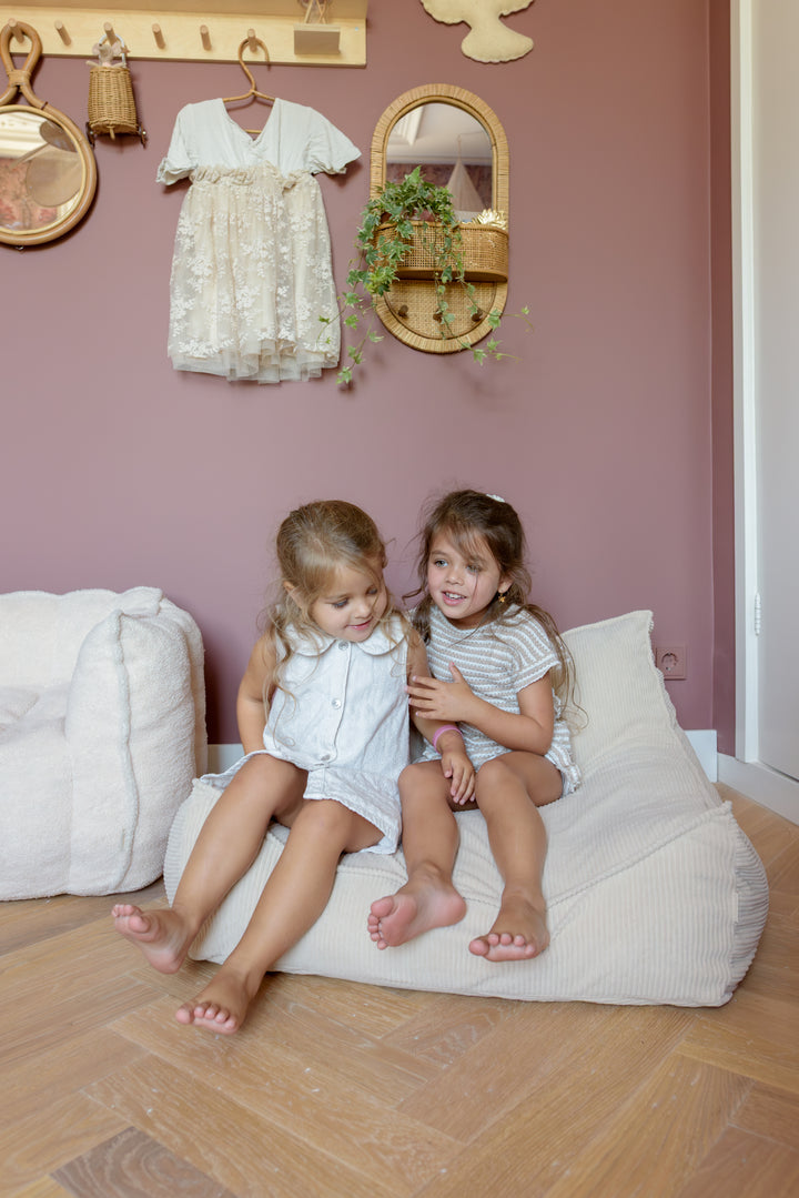 Toddler lounging on the Babiem beanbag Bruno, a soft seat for reading and resting.