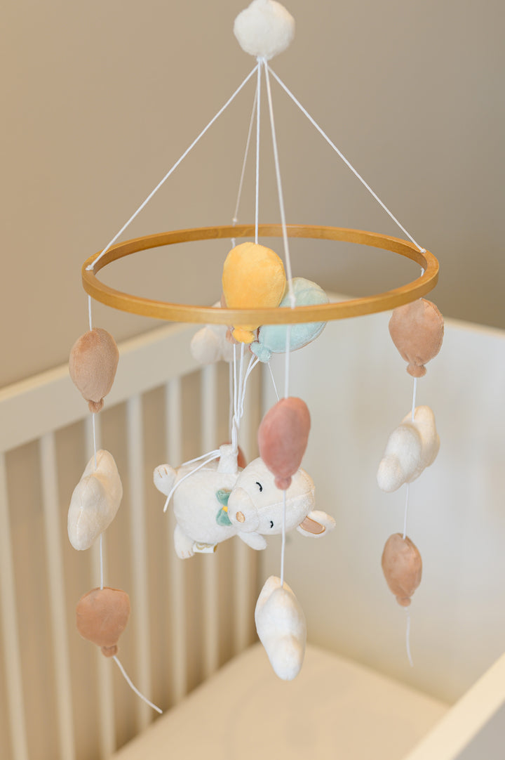 Babiem musical mobile Sam with plush balloons and clouds, gently hanging above a crib for a cozy nursery.