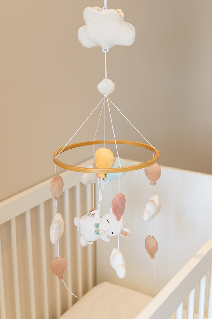 The Babiem music mobile Sam with a plush mouse, clouds, and balloons, adding a dreamy touch to the crib.