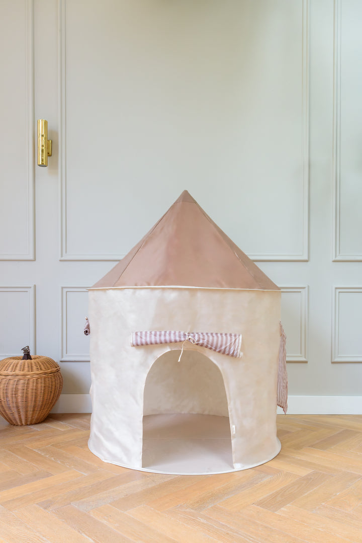Babiem play tent Alice, a round fabric tent in beige with a taupe roof and striped tie-back entrance, placed on a wooden floor in a softly lit room with minimal decor.