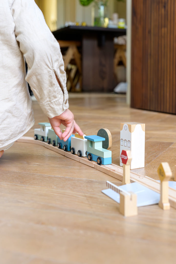 Child playing with the Babiem train set Felix with station and signs