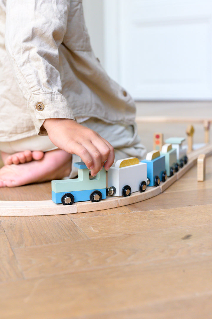 Child pushing wooden train from the Babiem train set Felix on railway track
