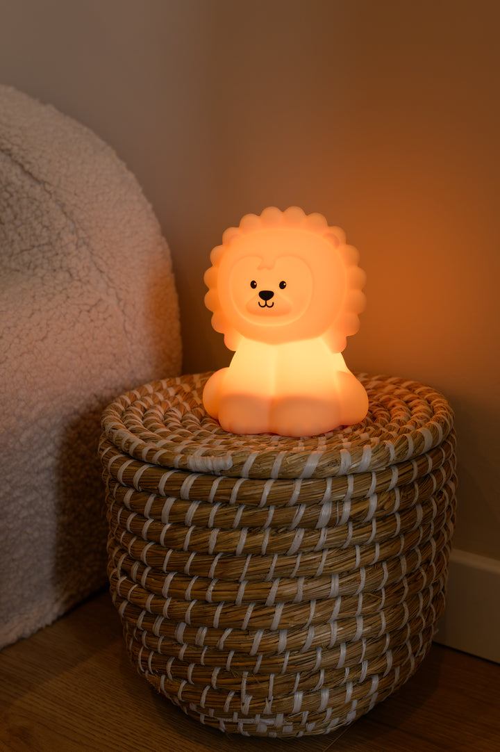 A softly glowing lion-shaped night light called Babiem Lucas, spreading warm orange light in a child’s room.