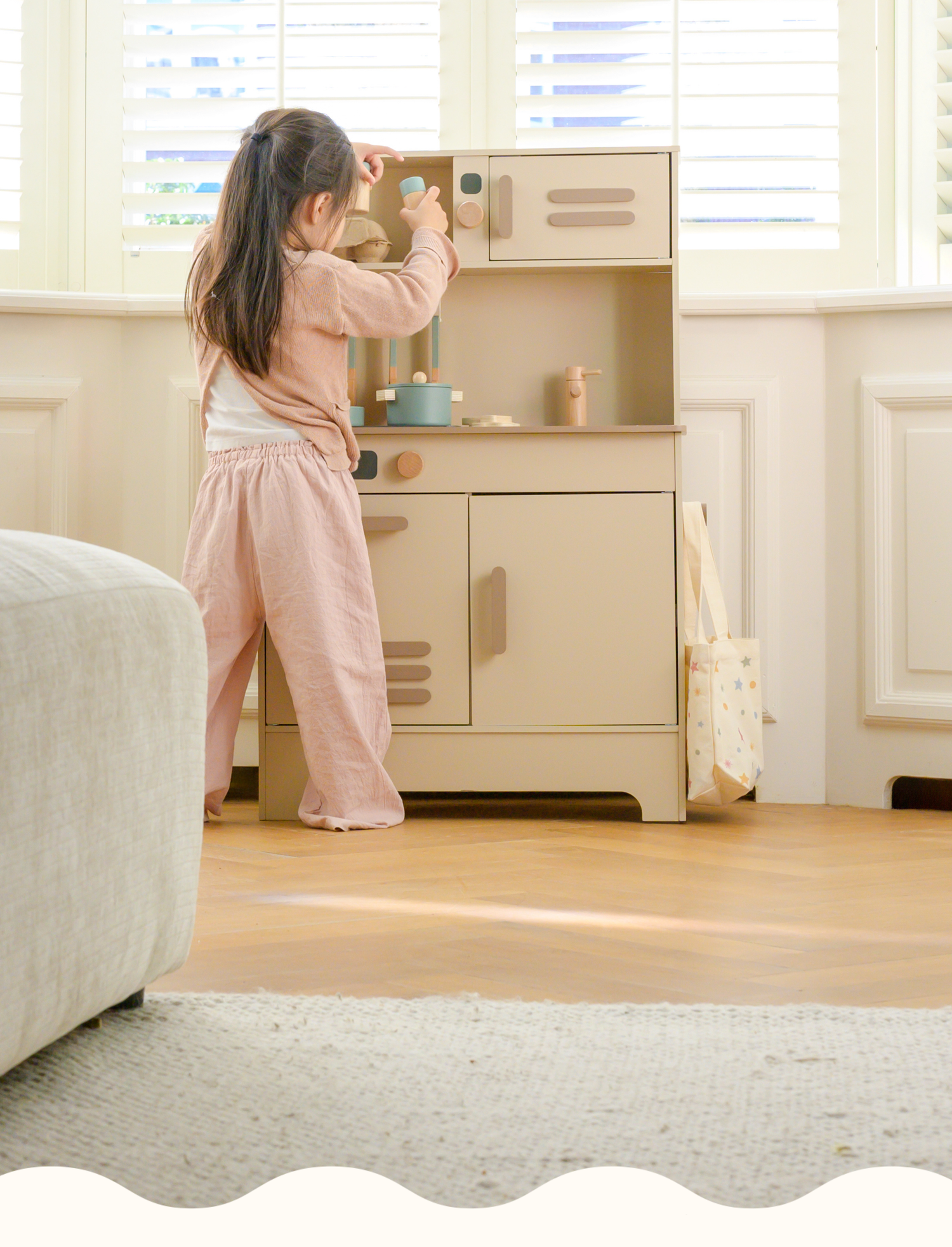 A little girl enjoying her time with Babiem’s play kitchen Noor , surrounded by soft light and natural tones. The design reflects Babiem’s love for quality, creativity, and sustainable play.