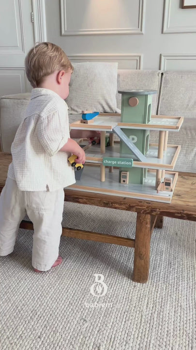 A montage of close-ups showing children interacting with a toy car park. Focus on small hands operating the car lift, sliding vehicles across tracks, and the vibrant details of the play set.