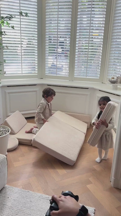 Close-up shots of kids creatively using the Max modular play sofa. The footage highlights how kids rearrange the foam cushions to build forts, tunnels, and cozy seating areas, showcasing the sofa's versatility.
